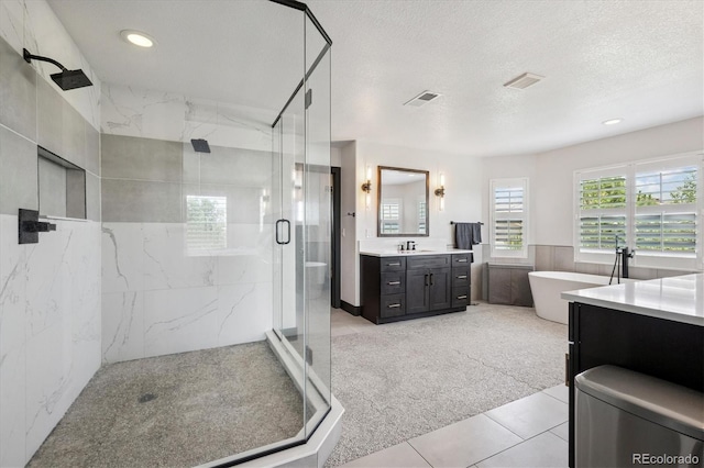 5665 Vistancia Ct, Parker, CO 80134 - bathroom featuring a marble finish shower, vanity, a freestanding bath, tile patterned floors, and a textured ceiling