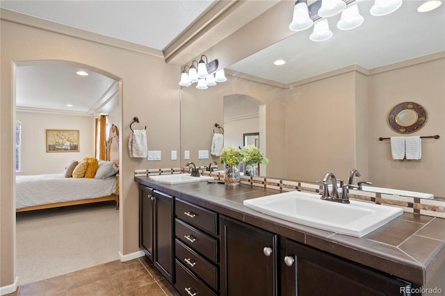 bathroom featuring ornamental molding, tile patterned flooring, a sink, and double vanity