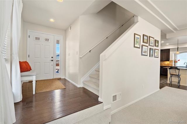 entrance foyer featuring baseboards, visible vents, dark wood-type flooring, stairs, and recessed lighting