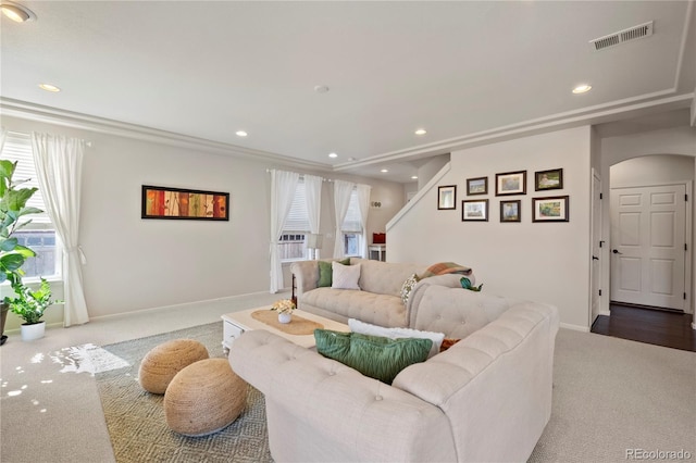 carpeted living area featuring recessed lighting, visible vents, arched walkways, and baseboards