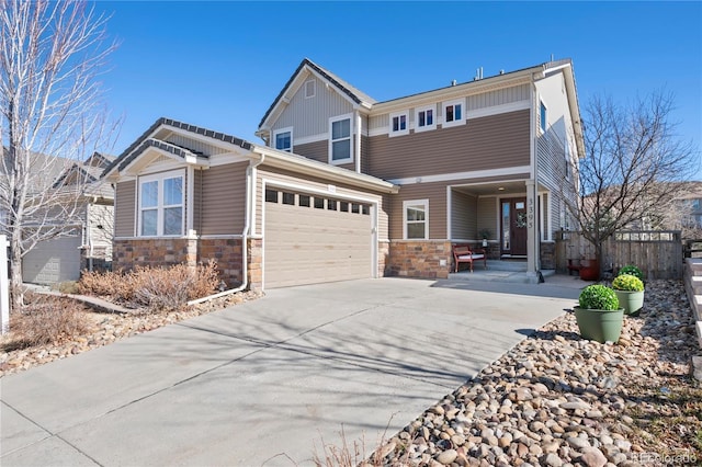 craftsman house featuring driveway, stone siding, and a garage