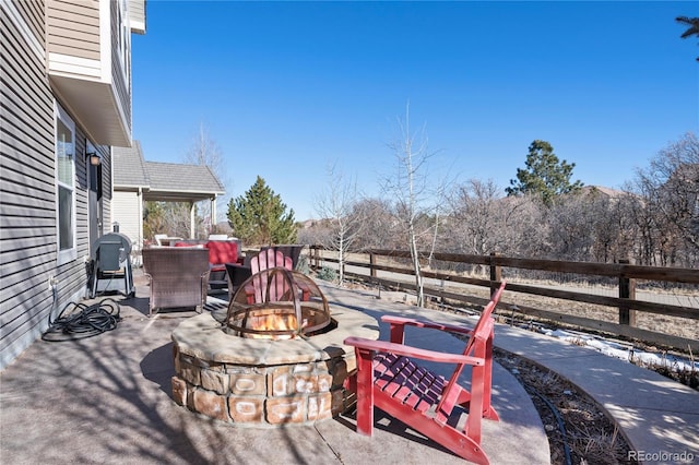 view of patio / terrace featuring an outdoor fire pit and fence