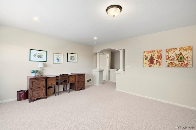 office area featuring arched walkways, visible vents, light carpet, and decorative columns