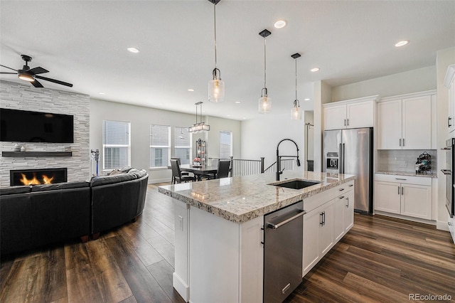 7169 Canyon Sky Trl, Castle Pines, CO 80108 - kitchen featuring stainless steel appliances, a sink, open floor plan, dark wood-style flooring, and recessed lighting