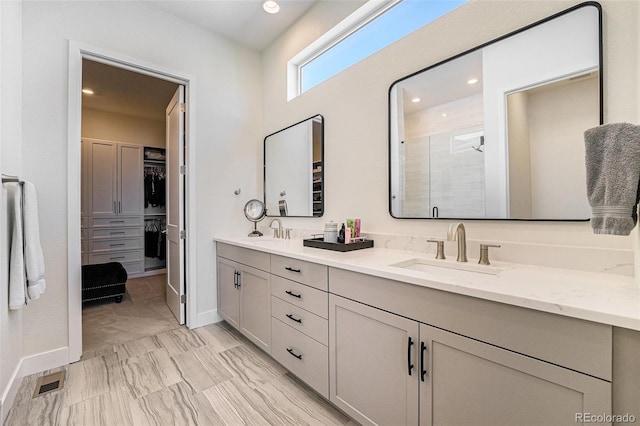 7169 Canyon Sky Trl, Castle Pines, CO 80108 - full bath with double vanity, a shower stall, a walk in closet, baseboards, and recessed lighting