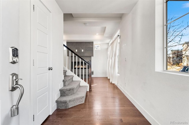 entrance foyer featuring stairs, baseboards, and dark wood-type flooring