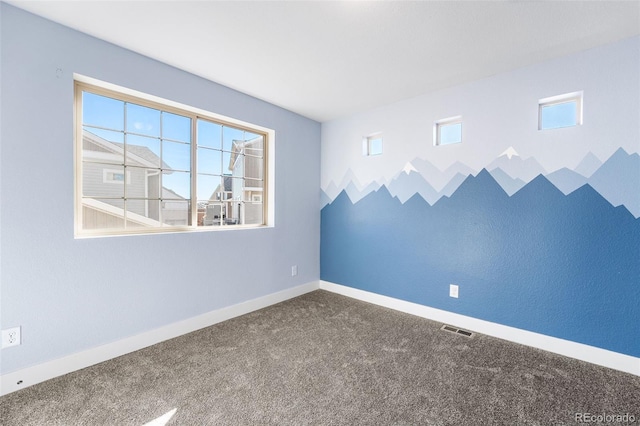 carpeted spare room featuring visible vents and baseboards