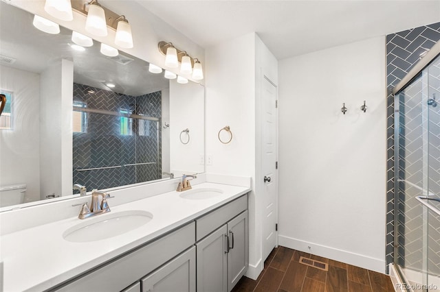 bathroom with toilet, wood tiled floor, a sink, and a shower stall