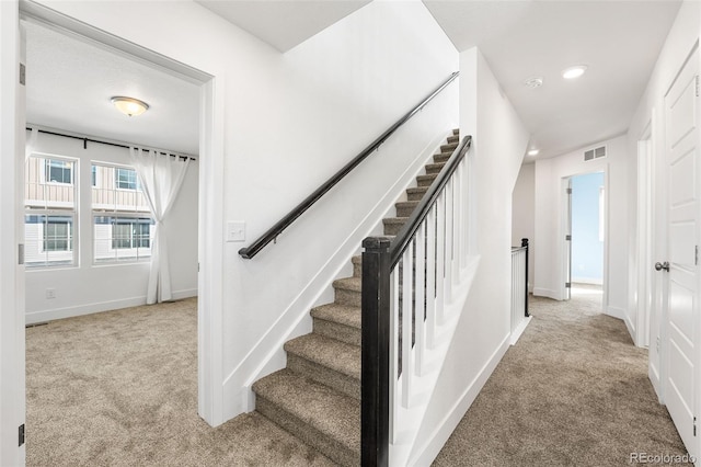 stairway with carpet floors, visible vents, and baseboards