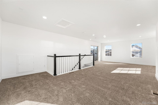 carpeted empty room with baseboards, visible vents, and recessed lighting