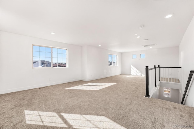 empty room with baseboards, recessed lighting, and light colored carpet