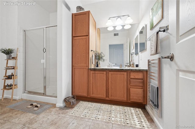 bathroom with walk in shower, tile patterned floors, vanity, and radiator