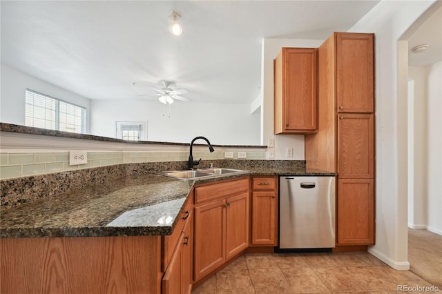 kitchen featuring sink, fridge, dark stone counters, and kitchen peninsula