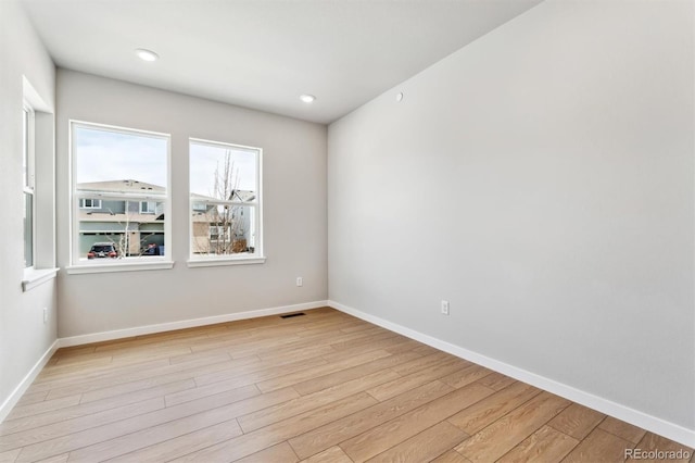 spare room featuring recessed lighting, light wood-style flooring, visible vents, and baseboards