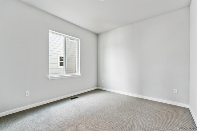 carpeted spare room with visible vents and baseboards