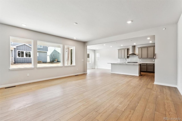 unfurnished living room with recessed lighting, baseboards, visible vents, and light wood-type flooring