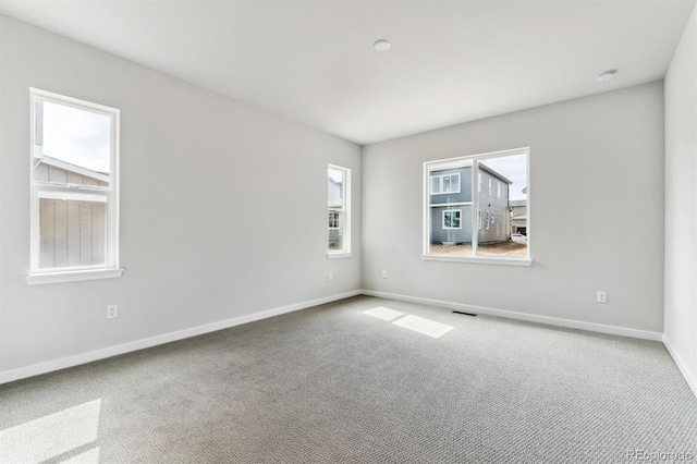 empty room with visible vents, baseboards, and carpet floors