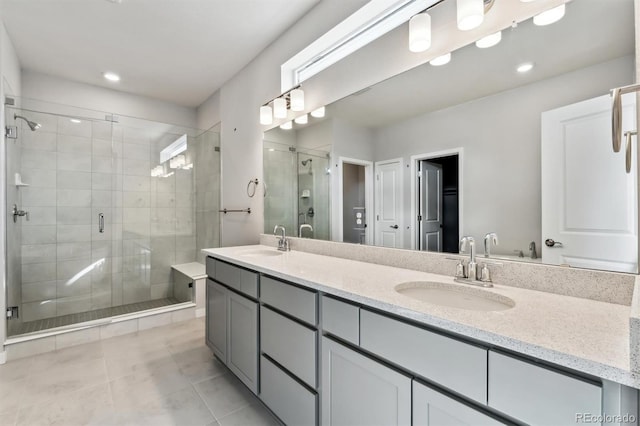 full bathroom with double vanity, recessed lighting, a stall shower, and a sink