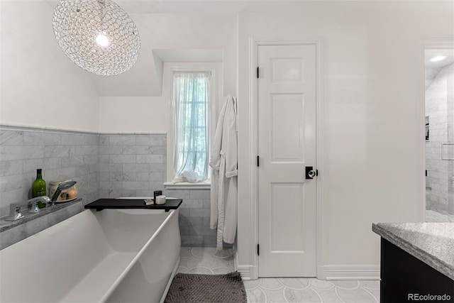 full bathroom featuring tile walls, a soaking tub, vanity, and tile patterned floors