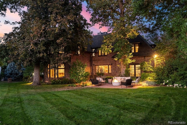 back of house featuring french doors, a patio area, a yard, and brick siding