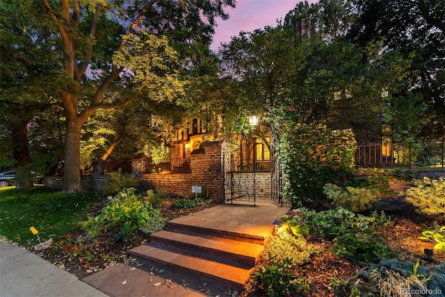 gate at dusk featuring fence