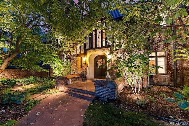 view of exterior entry with brick siding