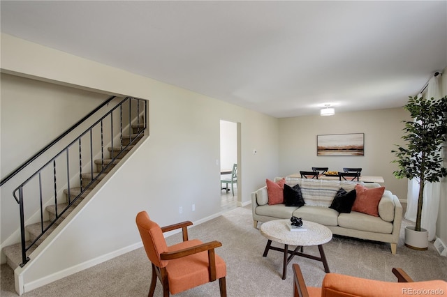 living area featuring baseboards, carpet flooring, and stairs