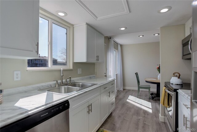 kitchen with appliances with stainless steel finishes, a sink, white cabinetry, and recessed lighting