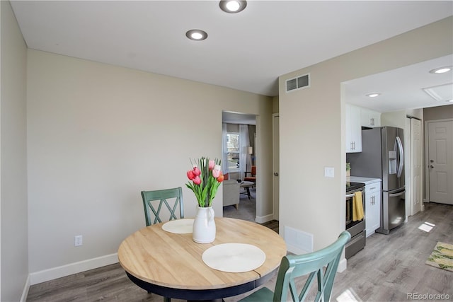 dining room with visible vents, baseboards, light wood-type flooring, and recessed lighting