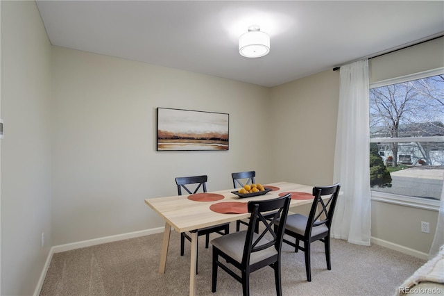 dining room featuring light carpet and baseboards