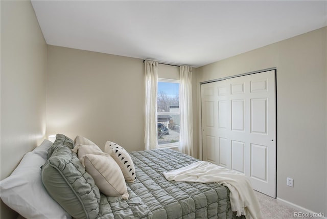 carpeted bedroom featuring a closet and baseboards