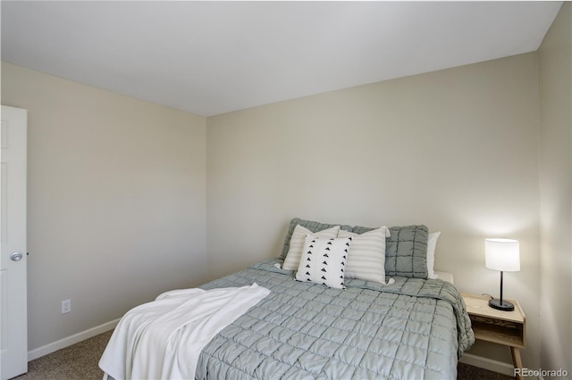 bedroom featuring baseboards and carpet