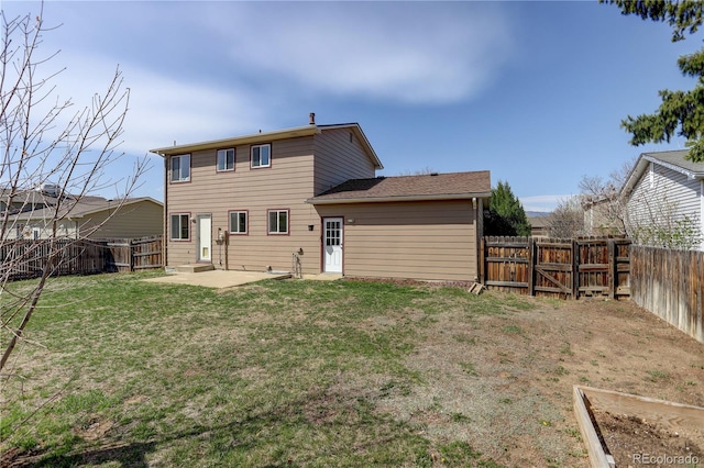 rear view of house featuring a yard, a patio area, a fenced backyard, and a gate