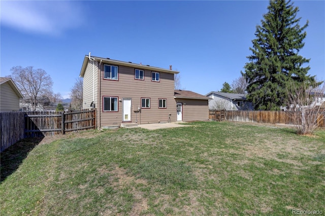 rear view of property with a yard, a fenced backyard, and a patio area