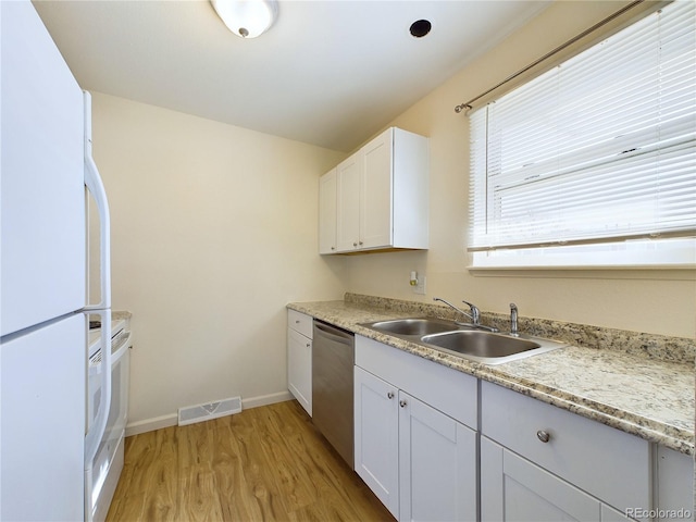 kitchen with white refrigerator, sink, stainless steel dishwasher, and white cabinets