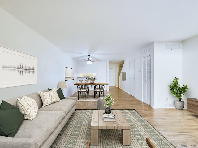 living room with ceiling fan and light hardwood / wood-style flooring