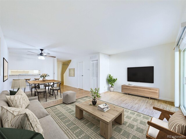 living room featuring hardwood / wood-style flooring and ceiling fan