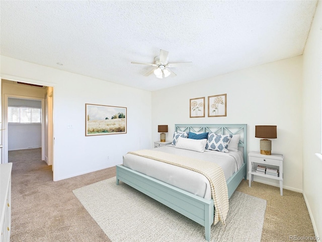 carpeted bedroom featuring ceiling fan and a textured ceiling