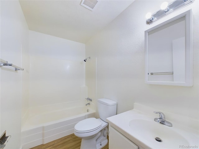 full bathroom featuring vanity, wood-type flooring, shower / bathtub combination, and toilet