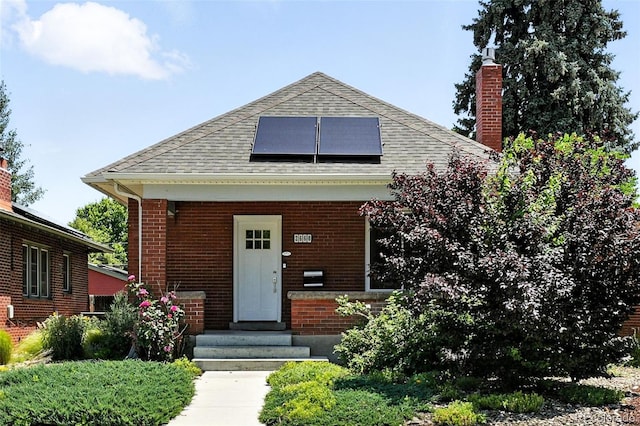 2660 Julian St, Denver, CO 80211 - bungalow featuring roof mounted solar panels, a chimney, brick siding, a shingled roof, and entry steps