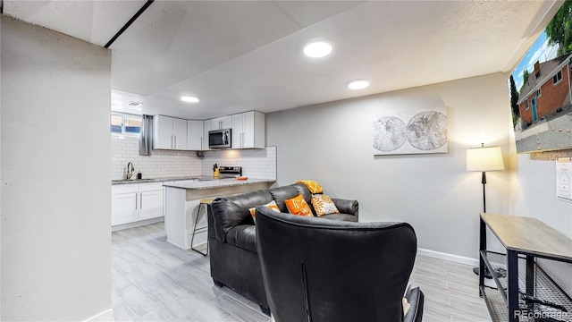 living room featuring sink and light hardwood / wood-style floors