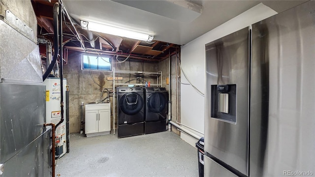 basement featuring stainless steel refrigerator with ice dispenser, washing machine and dryer, and water heater