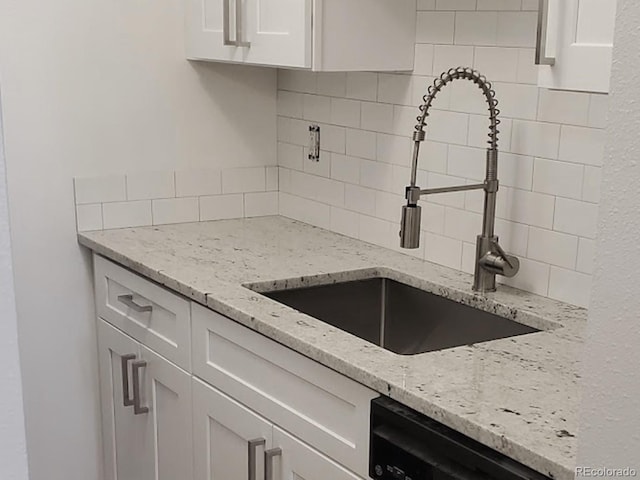 1633 18th St Unit 2, Boulder, CO 80302 - kitchen featuring a sink, tasteful backsplash, white cabinets, black dishwasher, and light stone countertops