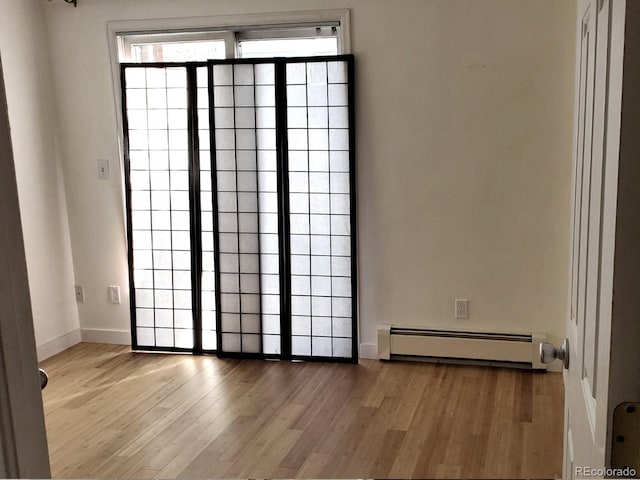 1633 18th St Unit 2, Boulder, CO 80302 - empty room featuring a baseboard radiator, wood finished floors, and baseboards
