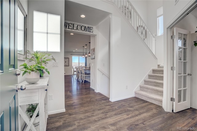 foyer entrance featuring dark hardwood / wood-style flooring and an inviting chandelier