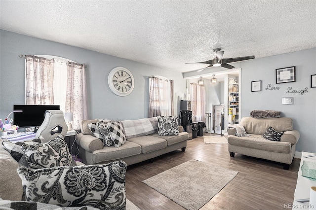 6411 E 64th Ave, Commerce City, CO 80022 - living room with healthy amount of natural light, wood finished floors, a ceiling fan, and a textured ceiling