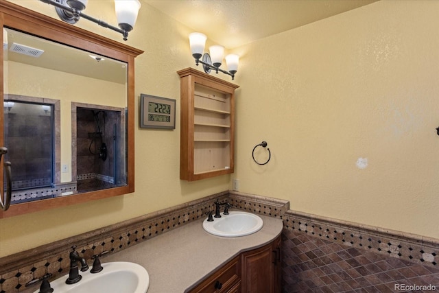 bathroom with a textured ceiling, vanity, and tile walls