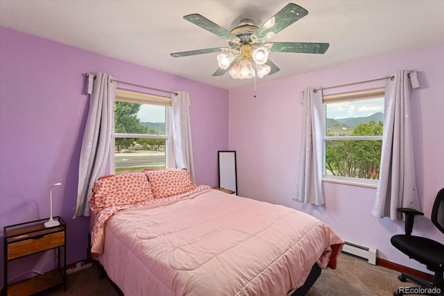 carpeted bedroom with ceiling fan and a baseboard radiator