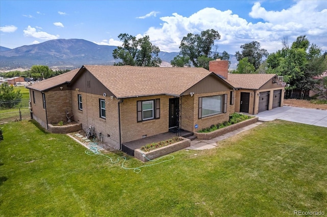 ranch-style home with a mountain view, a front lawn, and a garage