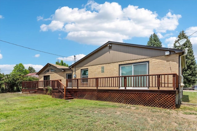 rear view of house with a lawn and a wooden deck